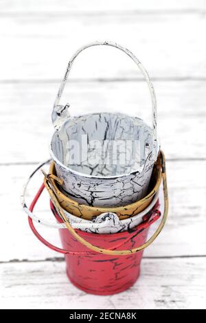 Empty miniature metal bucket on white wooden table Stock Photo