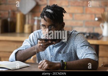 Close up serious African American man recording voice message Stock Photo