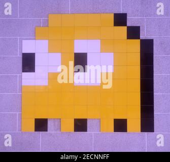 Pixelated image of Pac Man game character Kinkky, formed by tiles and mounted on wall Stock Photo