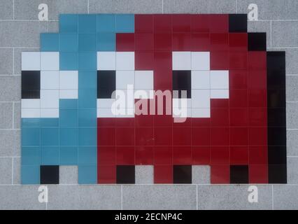 Pixelated image of Pac Man game character Inky and Blinky, formed  by  tiles and mounted on wall Stock Photo
