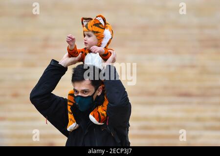 Valletta, Malta. 13th Feb, 2021. A man walks with a child dressed as a tiger sitting on his neck in Valletta, Malta, on Feb. 13, 2021. Maltese carnival enthusiasts do not let the COVID-19 pandemic dampen their passion for carnival as they still work on their colorful floats and exhibit them in a static art installation rather than a parade, in line with pandemic restrictions. Credit: Jonathan Borg/Xinhua/Alamy Live News Stock Photo