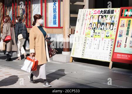 Person looks at an information board at Kabuki-za kabuki theater in Ginza, Tokyo. People wear face masks during the coronavirus outbreak. (2/2021) Stock Photo