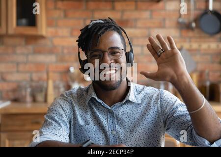 Head shot portrait smiling African American man wearing headphones greeting Stock Photo