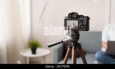 Woman blogger recording video indoors, selective focus on camera display. Space for text Stock Photo