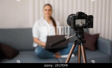 Woman blogger recording video indoors, selective focus on camera display. Space for text Stock Photo
