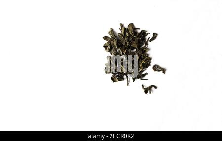 Black tea leaves on white isolated background.Black dry tea leaves. Stock Photo
