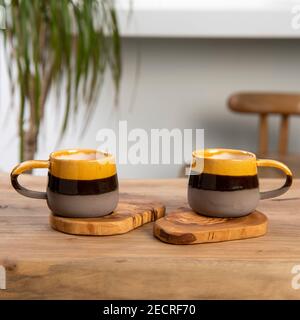 colorful handmade ceramic coffee cups on table Stock Photo