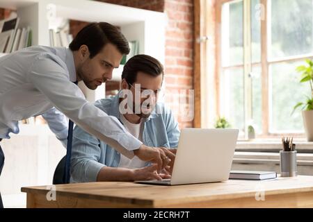 Male employees brainstorm work together on laptop Stock Photo