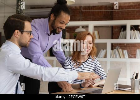 Smiling multiracial employees work together on computer in office Stock Photo