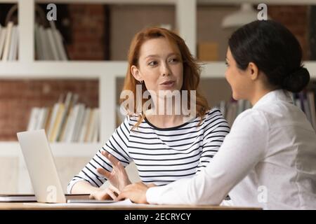 Multiracial female colleagues brainstorm ideas using laptop Stock Photo