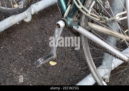 Closeup of details of a parked bicycle located in Zürich, Switzerland, March 2020. Color image with grey, silver, pink, green and yellow tones. Stock Photo