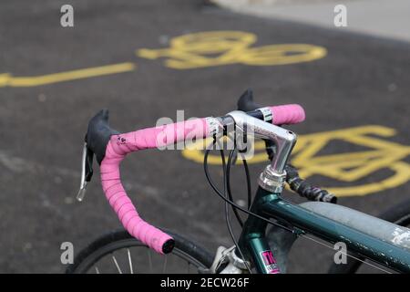 Closeup of details of a parked bicycle located in Zürich, Switzerland, March 2020. Color image with grey, silver, pink, green and yellow tones. Stock Photo