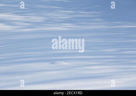 Clear and even blue snow with transverse shadow stripes. Stock Photo