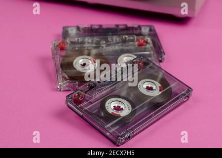 Collecting music recordings concept. Close-up of three audio cassettes with music recordings on a pink background. Selective focus. Stock Photo