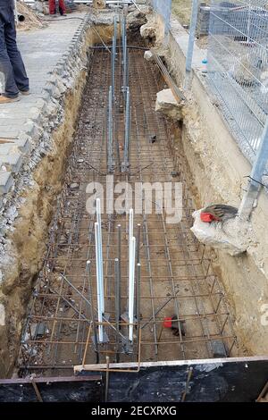 The location of the foundation of the new building, parts and fittings made of steel rods and wire, which are being prepared for pouring cement, const Stock Photo