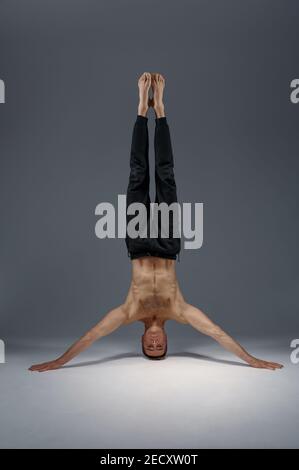 Male yoga standing on his head and hands Stock Photo