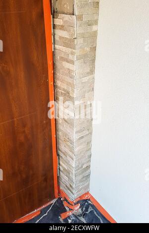 Work with decorative stone, the corner near the door is lined with decorative stones.2021 Stock Photo