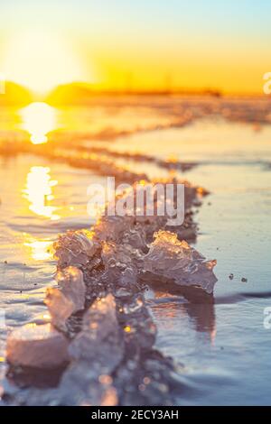 Sunset over a frozen body of water Stock Photo
