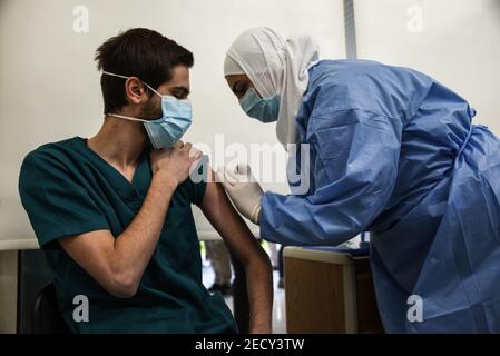 Beirut, Lebanon, 14 February, 2021. Healthcare staff receiving some of Lebanons first Covid-19 vaccines as the country begins its vaccination program with 28 thousand doses of the Pfizer-Biontech vaccine. Elizabeth Fitt Credit: Elizabeth Fitt/Alamy Live News Stock Photo