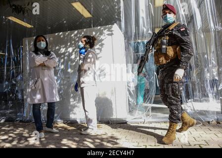 Beirut, Lebanon, 14 February, 2021. An armed guard at the entrance to Rafik Hariri University Hospital's vaccination center as Lebanon begins its Covid-19 vaccine program by vaccinating medical staff on Valentines Day. Elizabeth Fitt Credit: Elizabeth Fitt/Alamy Live News Stock Photo