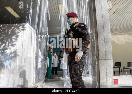 Beirut, Lebanon, 14 February, 2021. An armed guard at the entrance to Rafik Hariri University Hospital's vaccination center as Lebanon begins its Covid-19 vaccine program by vaccinating medical staff on Valentines Day. Elizabeth Fitt Credit: Elizabeth Fitt/Alamy Live News Stock Photo