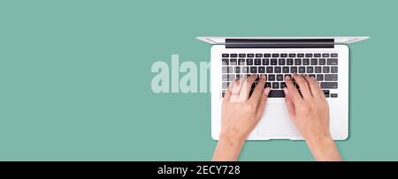 Businessman using laptop computer isolated on green background, business man typing keyboard on notebook with copyspace from above, network and commun Stock Photo