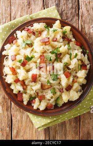 Strapacky or sztrapacska is a dish popular in Slovakia and Hungary made of  halusky with sauerkraut and bacon closeup in the plate on the table. Verti Stock Photo
