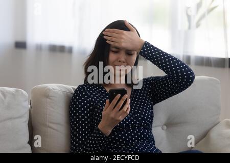 Sad confused vietnamese lady hold cell see missed important call Stock Photo