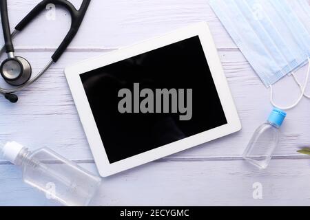top view of digital tablet, hand sanitizer and stethoscope on table  Stock Photo