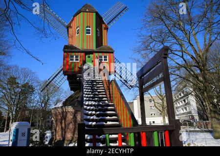 Viersen (Dulken), Germany - February 9. 2021: View beyond steps on red green colorfull striped wind mill (Narrenmuhle) against blue sky in winter Stock Photo
