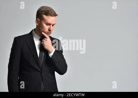 Attractive man in a suit is thinking how to solve a problem Stock Photo