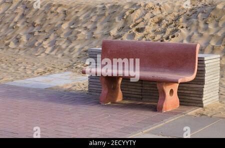 A pink bench with tiles stacked in front of a sand dune (Pesaro, Italy, Europe) Stock Photo
