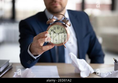 Close up of businessman hold clock worried about deadline Stock Photo