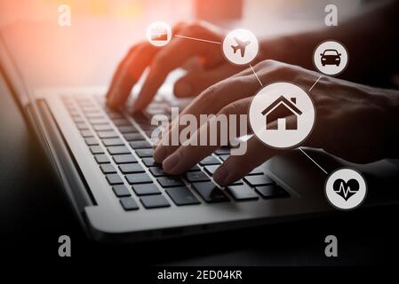 Home, health, travel insurance. Hands on laptop, insurance agent at work. Stock Photo