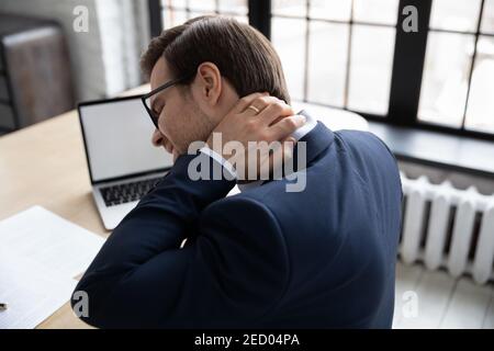 Caucasian male employee struggle with neck pain Stock Photo