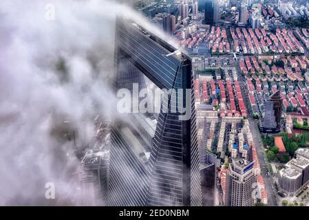 Shanghai, China - April 20, 2019: View of Shanghai World Financial Center emerging from clouds. The WFC  is a supertall skyscraper located in Pudong Stock Photo
