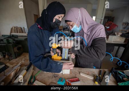 Bethlehem. 14th Feb, 2021. Palestinian women work at their carpentry shop in Al-Walajah village near the West Bank city of Bethlehem, on Feb. 14, 2021. Five years ago seven Palestinian housewives started their own project on wood recycling to make a living, turning waste timber into usable products, which were sold to souvenir shops and on social media. Credit: Luay Sababa/Xinhua/Alamy Live News Stock Photo