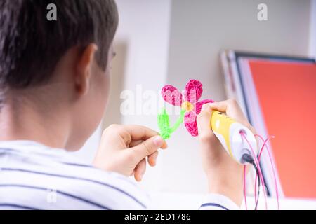 Boy creating new 3d object with 3d pen. Learning and entertainment at home Stock Photo
