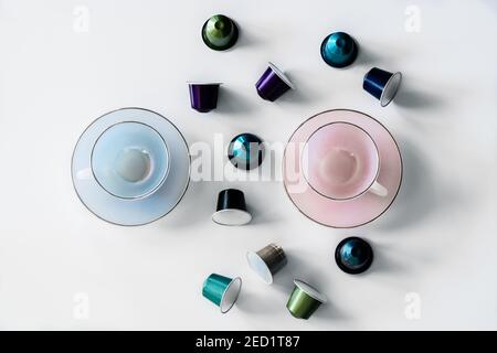 Top view of collection of coffee pods placed near empty ceramic mug and saucer on white background Stock Photo