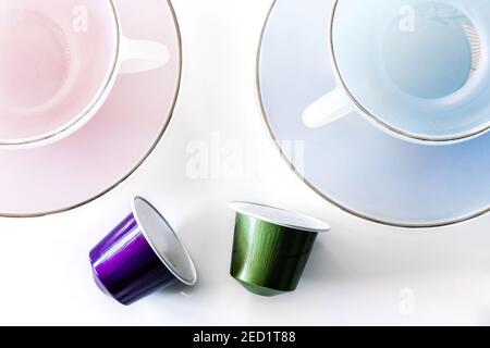 Top view of collection of coffee pods placed near empty ceramic mug and saucer on white background Stock Photo
