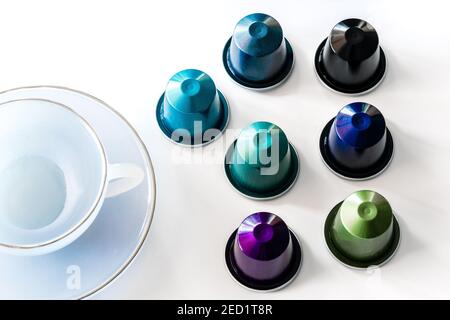 Top view of collection of coffee pods placed near empty ceramic mug and saucer on white background Stock Photo