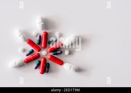 Assorted colorful and white pills and capsules placed on white table Stock Photo