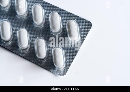 Closeup top view of full frame background of various white pills in plastic blister Stock Photo