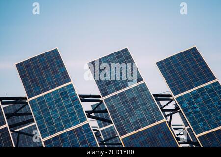 Modern solar panels installed in field against cloudy sky in photovoltaic power station Stock Photo