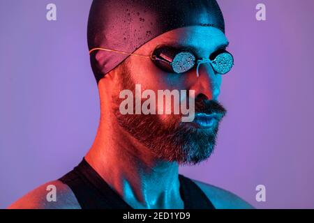 Side view studio portrait of a swimmer with cap and goggles Stock Photo