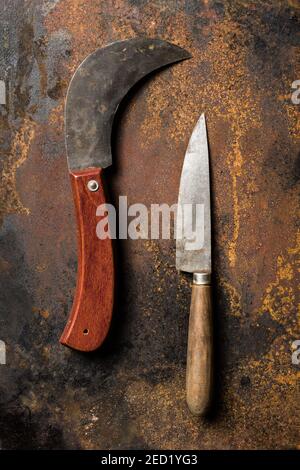 Top view of sharp knives with shabby blades placed on rusty metal table Stock Photo