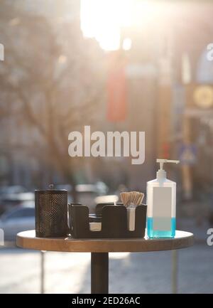 safety measures during covid 19 quarantine - table with sanitizer in public place in front of coffee shop Stock Photo