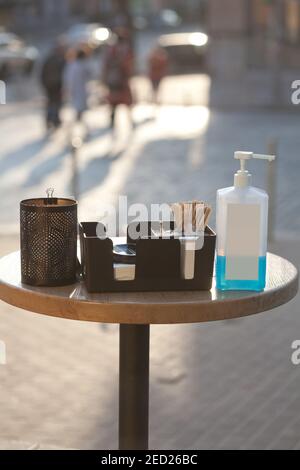 safety measures during covid 19 quarantine - table with sanitizer in public place in front of coffee shop Stock Photo