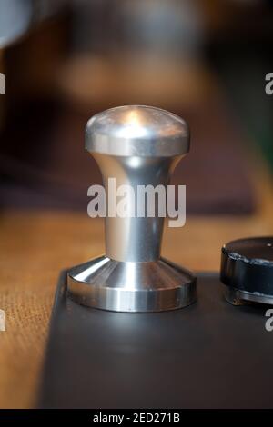 temper for espresso holder standing on rubber pad in coffee shop, closeup, nobody Stock Photo