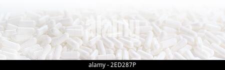 Long panoramic background with whites medical capsules. Selective focus Stock Photo